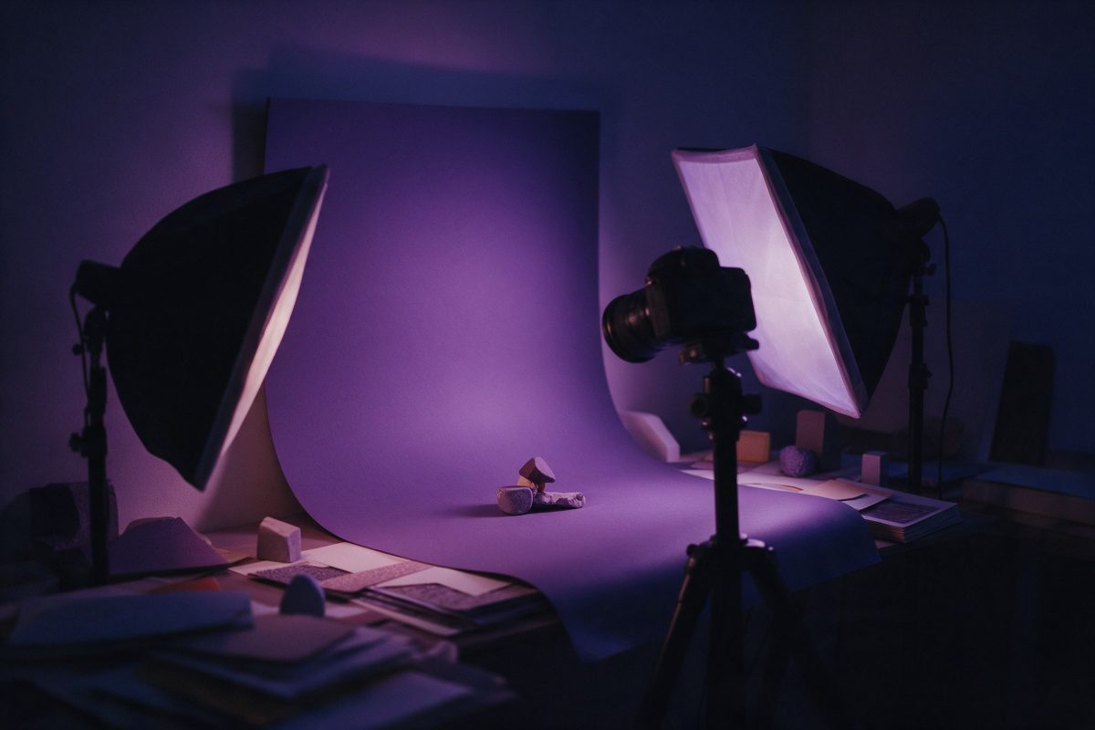 Fon kâğıdı önünde küçük bir nesneye yönelmiş softbox ışıklar ve tripod üzerindeki fotoğraf makinesi