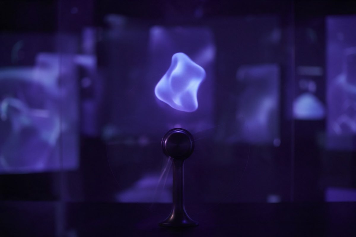 Karanlık bir teşhir salonunda havada soyut ışıklı bir biçim gösteren hologram fanı