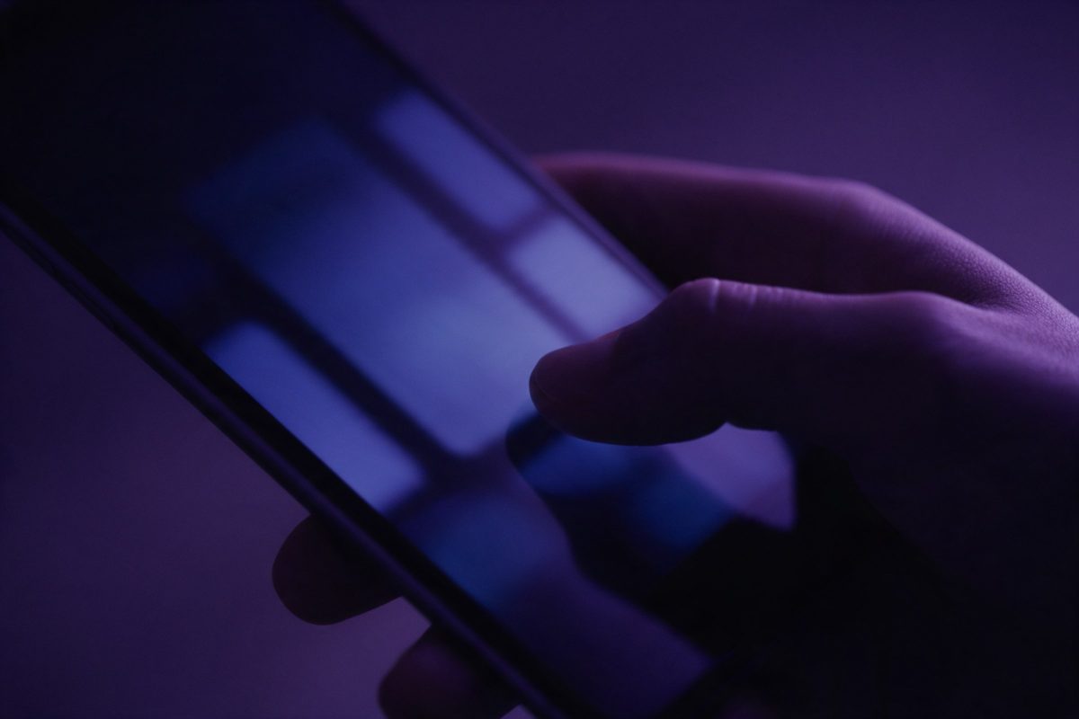 Bulanık bir uygulama arayüzü açık telefonu tutan el
