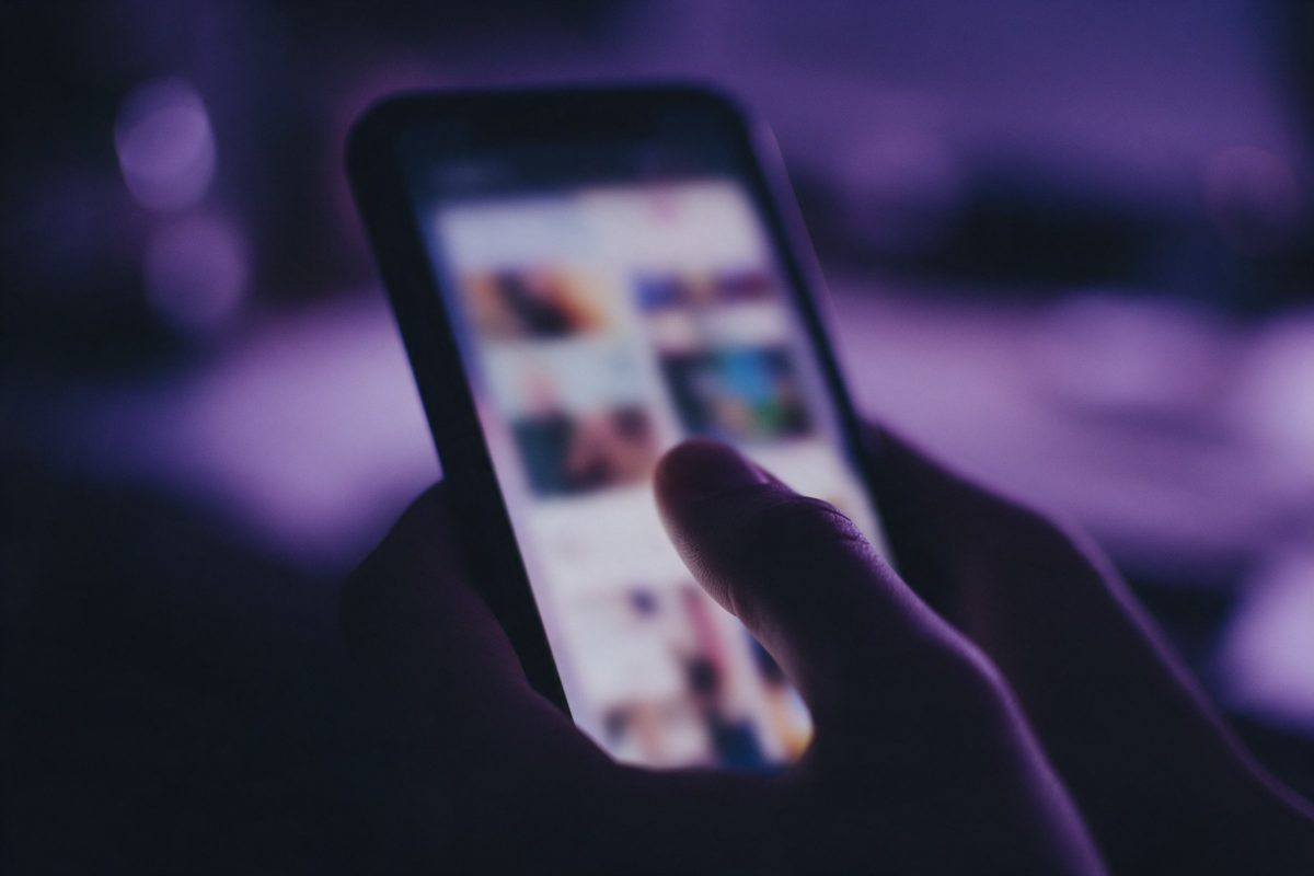 Ekranı bulanık görsel karelerle dolu telefonu başparmağıyla kaydıran el